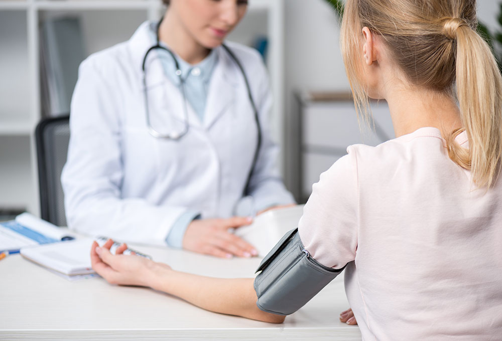 24-Stunden-­Blutdruckmessung - Ärztin misst Blutdruck bei Patientin