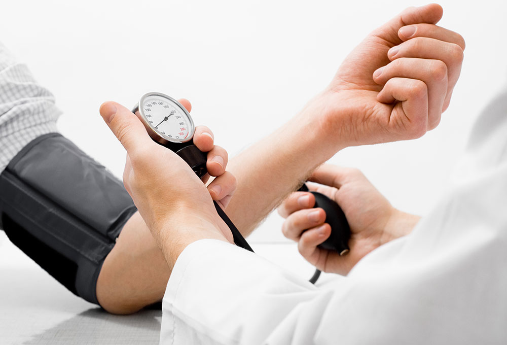 Bklutdruckmessung - Arzt hält Blutdruckmessgetät in der Hand 